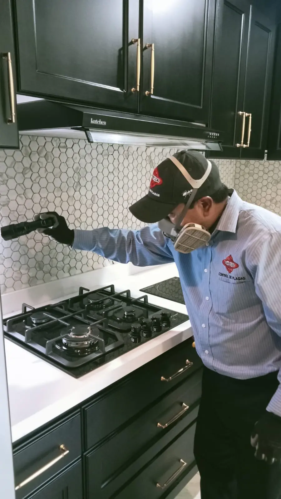 Técnico de FUMIESCAL inspeccionando una cocina con equipo de protección